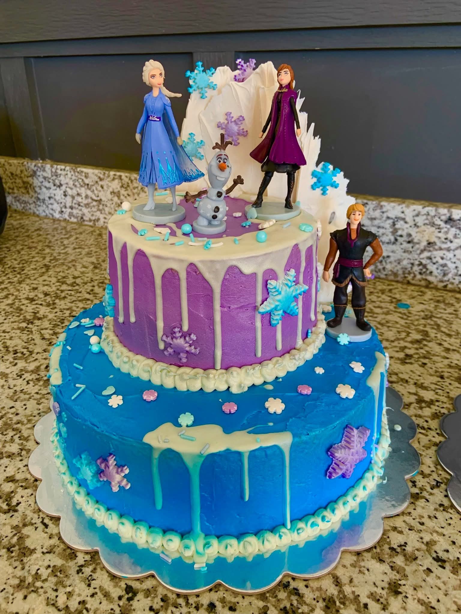 Custom Frozen themed tiered birthday cake with Elsa, Anna, Olaf and Kristoff figurines